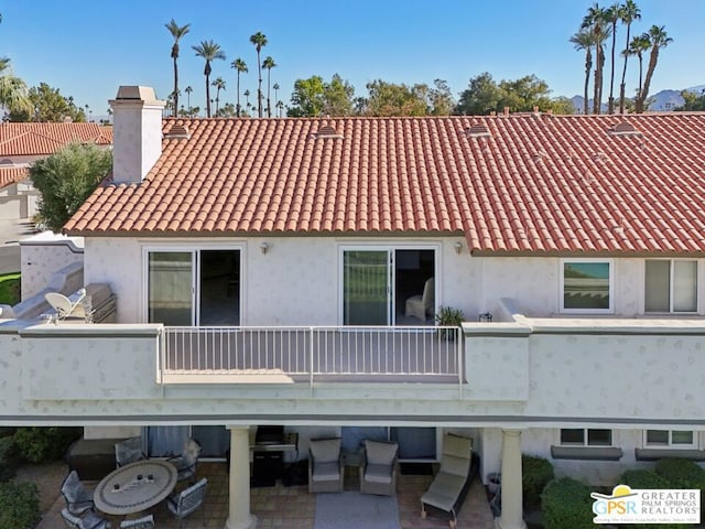 rear view of house with a balcony and a patio area