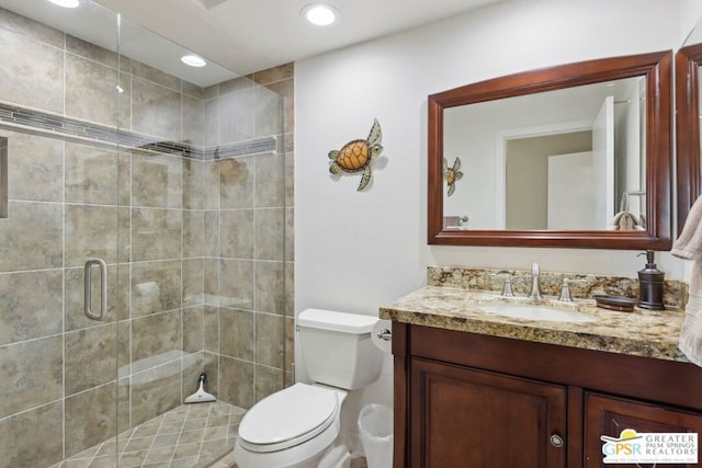 bathroom featuring vanity, toilet, and an enclosed shower