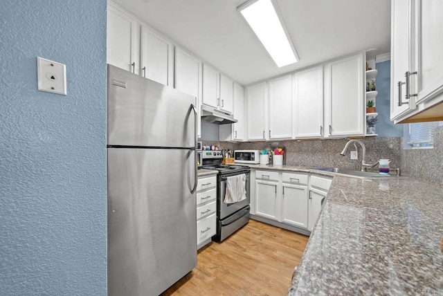 kitchen featuring white cabinetry, sink, stainless steel appliances, light hardwood / wood-style flooring, and decorative backsplash