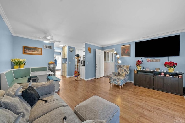 living room with crown molding, ceiling fan, and light wood-type flooring