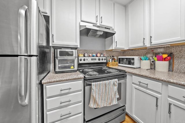 kitchen featuring tasteful backsplash, white cabinets, and appliances with stainless steel finishes