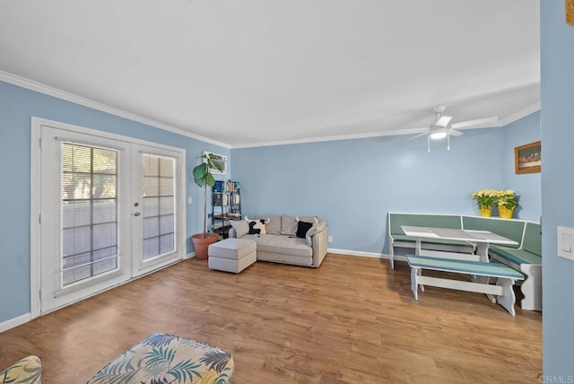 living room featuring french doors, light hardwood / wood-style floors, ceiling fan, and ornamental molding