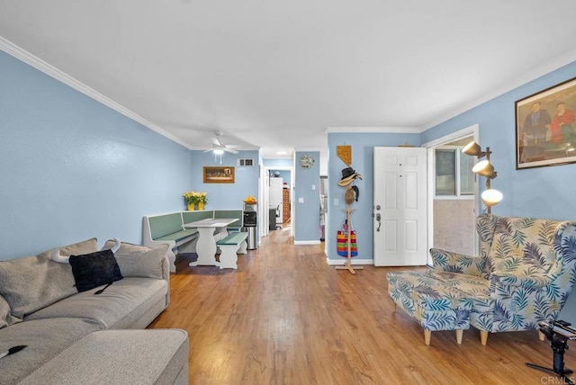 living room featuring light hardwood / wood-style flooring, ceiling fan, and ornamental molding