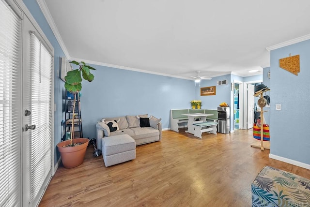 living room featuring ceiling fan, light wood-type flooring, and ornamental molding