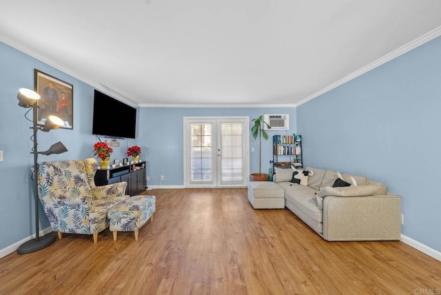 living room with light hardwood / wood-style floors, an AC wall unit, crown molding, and french doors