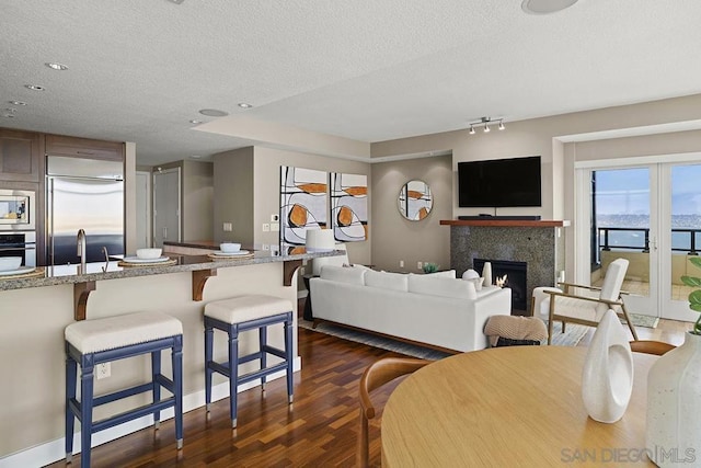 living room with dark hardwood / wood-style floors, sink, and a textured ceiling