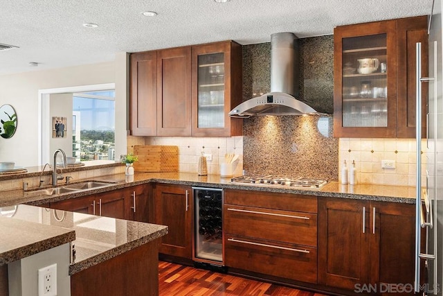 kitchen featuring dark hardwood / wood-style floors, sink, beverage cooler, stainless steel gas cooktop, and wall chimney exhaust hood