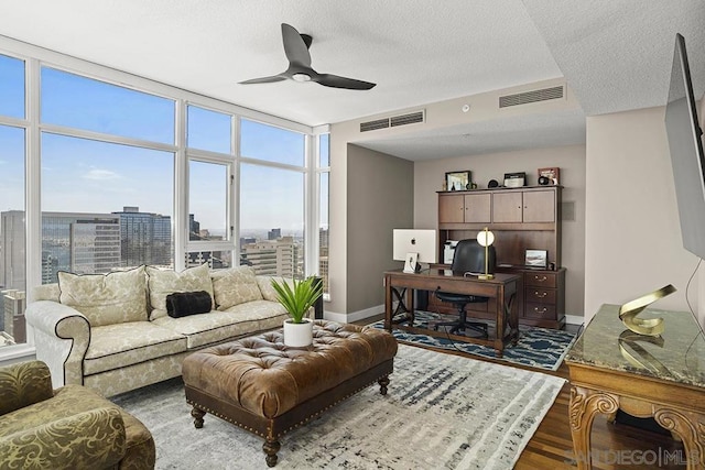 living room with hardwood / wood-style flooring, expansive windows, a textured ceiling, and ceiling fan