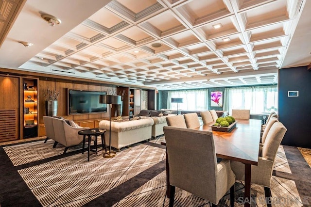 dining space featuring coffered ceiling and wood walls