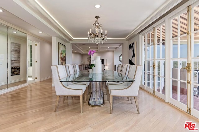 dining space featuring french doors, light hardwood / wood-style floors, an inviting chandelier, and crown molding