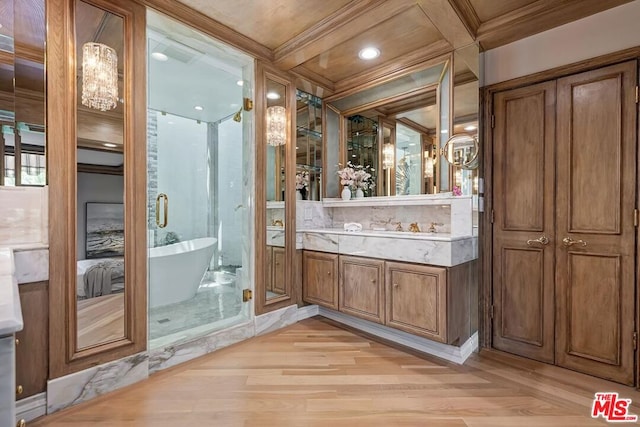 bathroom featuring ornamental molding, coffered ceiling, vanity, wood-type flooring, and a tub