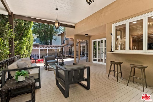 wooden terrace with an outdoor living space and an outdoor bar