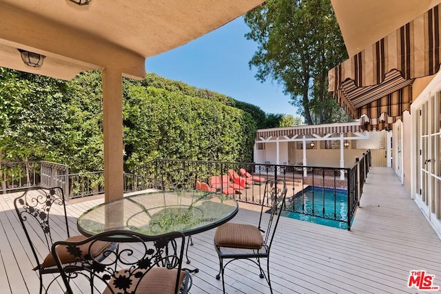 wooden deck with a fenced in pool