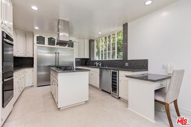 kitchen with tasteful backsplash, a center island, white cabinets, and stainless steel appliances