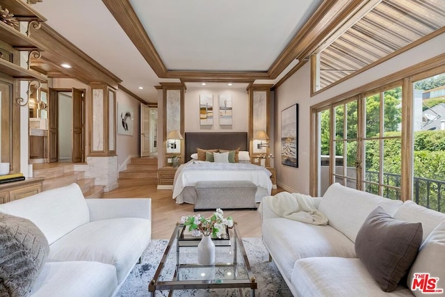 bedroom featuring decorative columns, crown molding, and light hardwood / wood-style floors