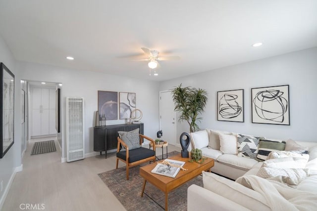 living room with ceiling fan and light hardwood / wood-style flooring