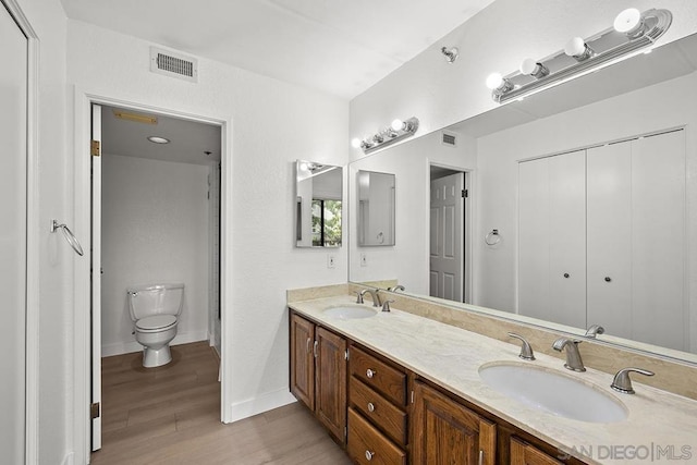 bathroom featuring vanity, toilet, and hardwood / wood-style floors