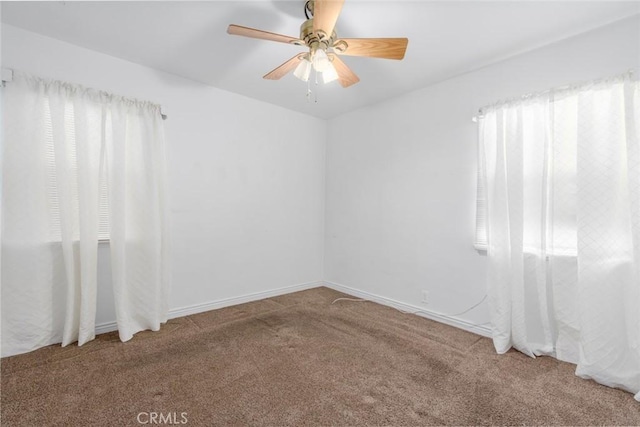 unfurnished room with ceiling fan and carpet