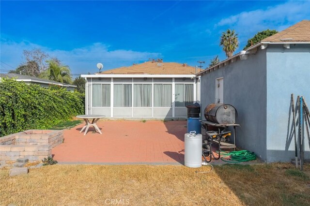 back of house with a patio area, a yard, and a sunroom