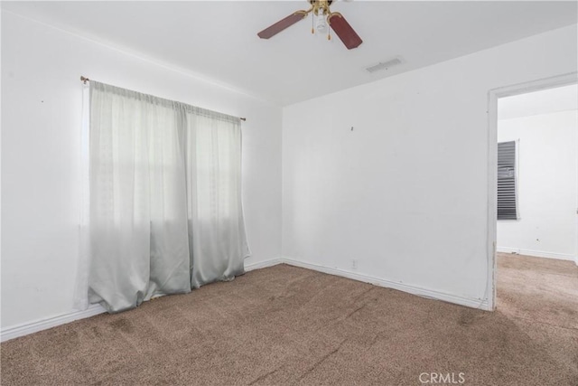 carpeted spare room with ceiling fan