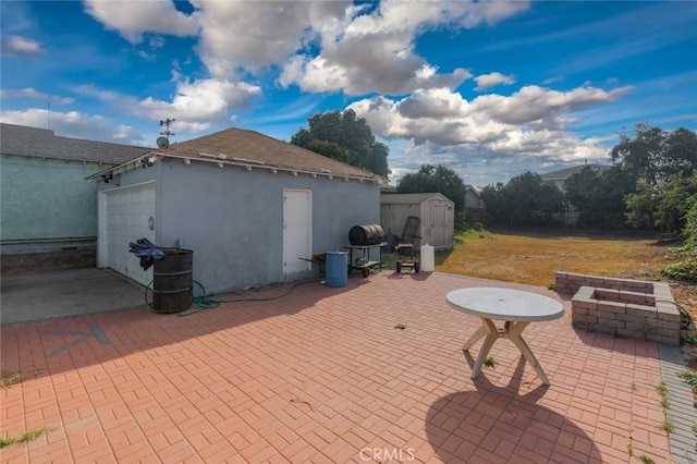 view of patio / terrace featuring a garage and a storage shed