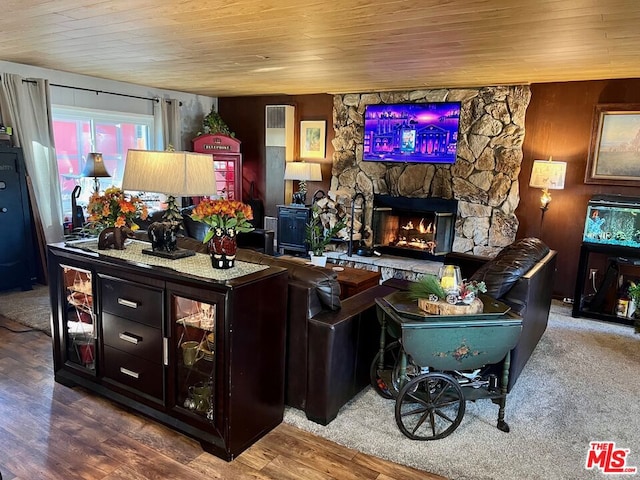 living room featuring a fireplace, wooden walls, hardwood / wood-style flooring, and wooden ceiling