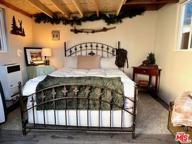 bedroom with beamed ceiling and heating unit