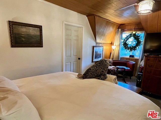 bedroom featuring ceiling fan, wooden ceiling, and wood walls