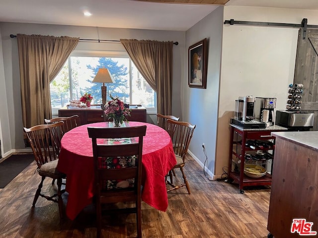 dining area with a barn door and dark wood-type flooring