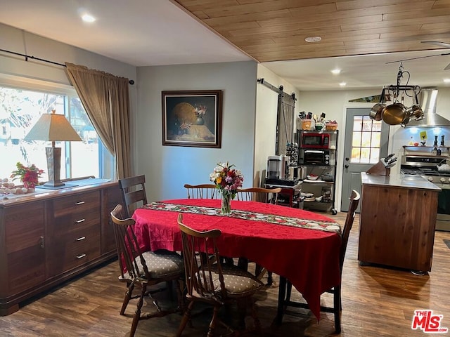 dining space with a barn door and dark wood-type flooring