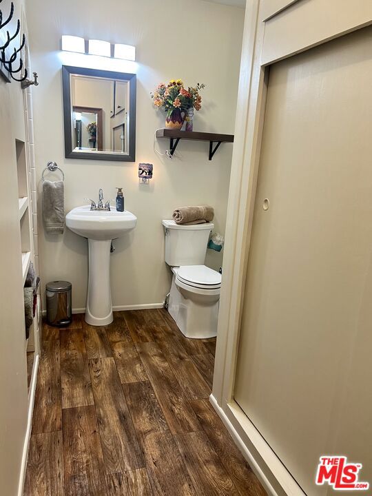 bathroom with toilet and hardwood / wood-style flooring