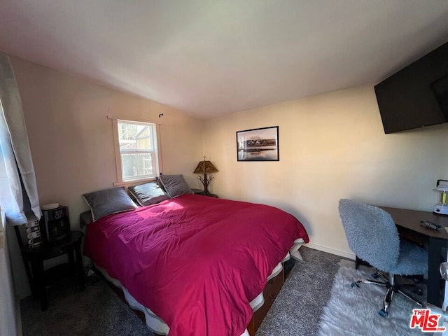 carpeted bedroom with lofted ceiling