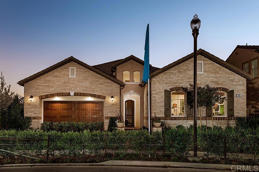 view of front of house featuring stone siding, fence, and an attached garage