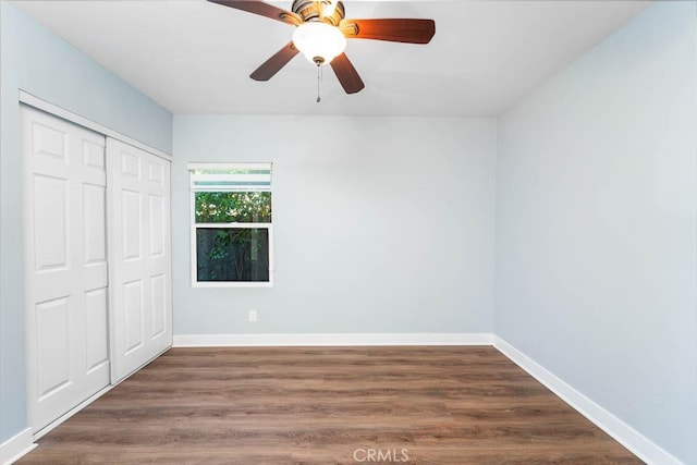 unfurnished bedroom featuring ceiling fan, a closet, and dark hardwood / wood-style floors