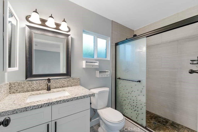 bathroom featuring toilet, walk in shower, and vanity