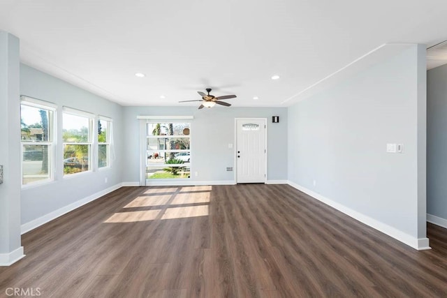 unfurnished living room with ceiling fan and dark hardwood / wood-style flooring