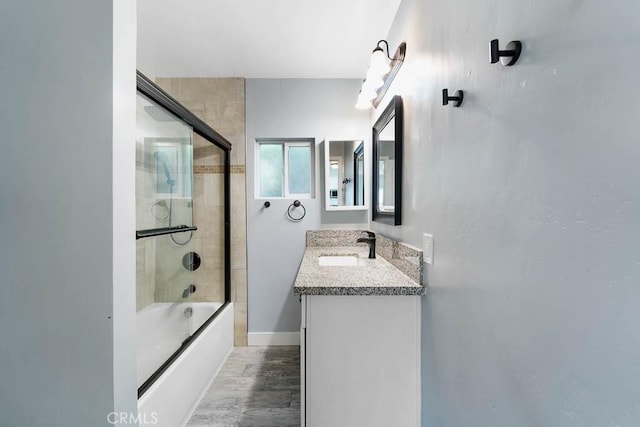 bathroom featuring shower / bath combination with glass door and vanity