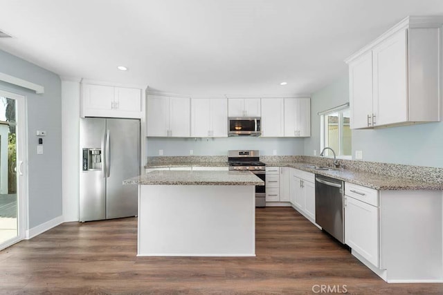 kitchen with white cabinetry, stainless steel appliances, dark hardwood / wood-style floors, a kitchen island, and sink