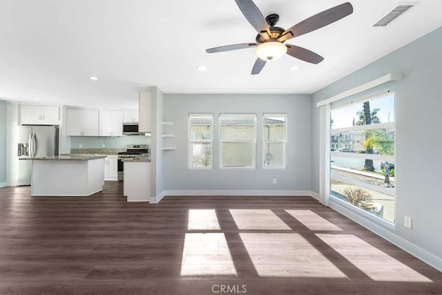 unfurnished living room featuring ceiling fan and dark wood-type flooring