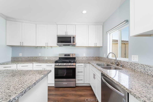 kitchen with dark hardwood / wood-style floors, sink, light stone countertops, appliances with stainless steel finishes, and white cabinets