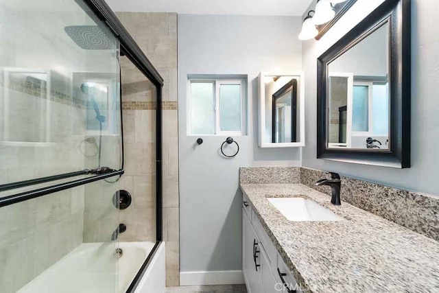 bathroom with combined bath / shower with glass door and vanity