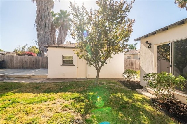 rear view of property featuring a patio and a yard