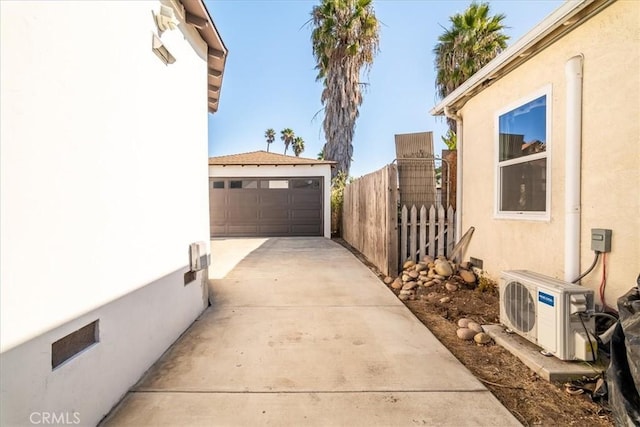 view of side of home with a garage and ac unit