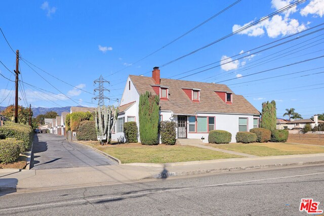 new england style home featuring a front lawn