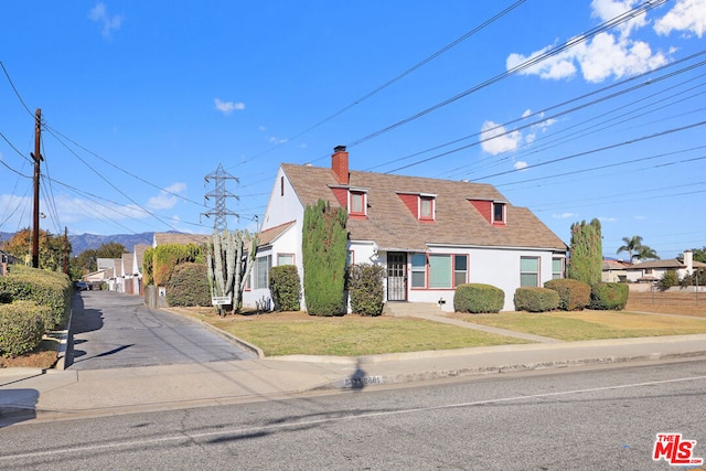 cape cod house featuring a front lawn