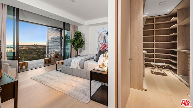 bedroom featuring light hardwood / wood-style floors and a wall of windows