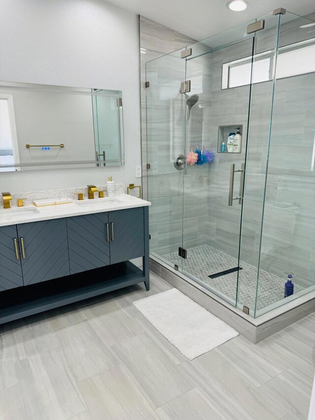 bathroom with vanity and a shower with door