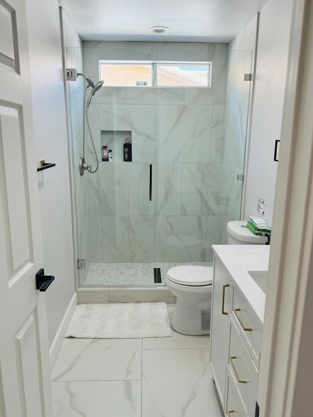 bathroom featuring toilet, a shower with shower door, and vanity