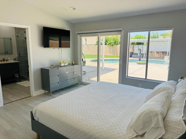 bedroom with access to outside, ensuite bath, and vaulted ceiling