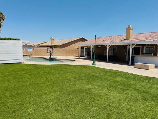 back of property with a patio area, a fenced in pool, and a lawn